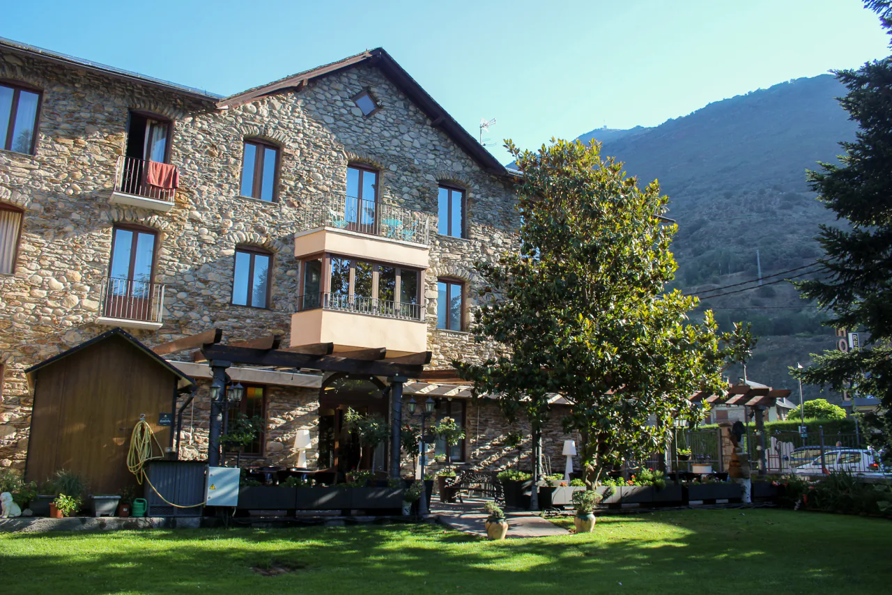 The guesthouse's stone building with the garden and outdoor tables
